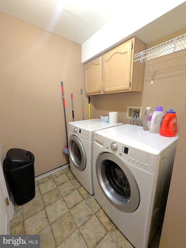 laundry room with washing machine and dryer and cabinets