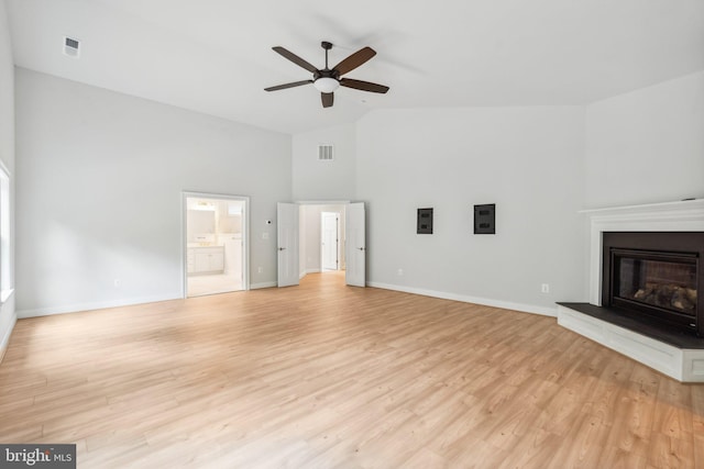 unfurnished living room featuring ceiling fan, light hardwood / wood-style flooring, and vaulted ceiling