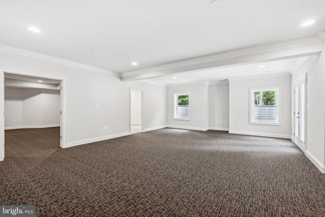 empty room featuring dark colored carpet, plenty of natural light, and crown molding