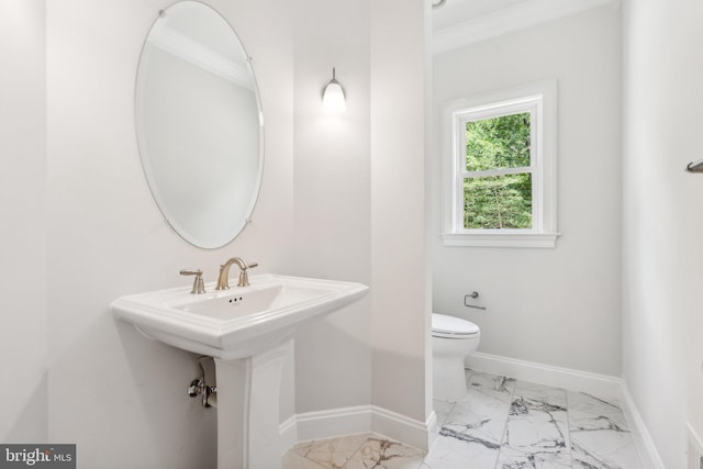 bathroom featuring sink, toilet, and ornamental molding