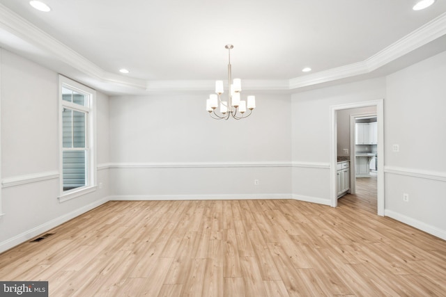 empty room with a raised ceiling, crown molding, and plenty of natural light