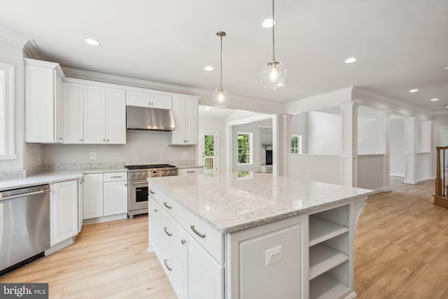 kitchen with decorative light fixtures, white cabinets, stainless steel appliances, and a kitchen island