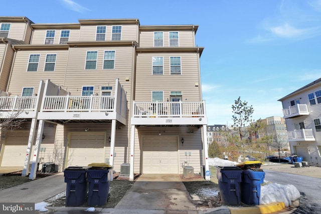 back of property featuring a garage and central air condition unit