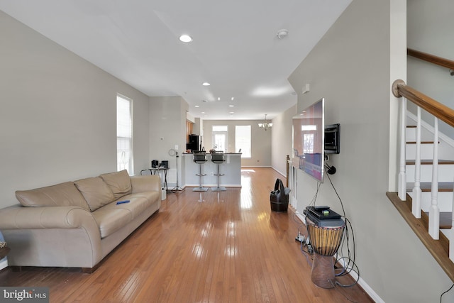 living room with a chandelier and light wood-type flooring