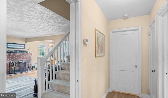 stairway featuring a fireplace and wood-type flooring