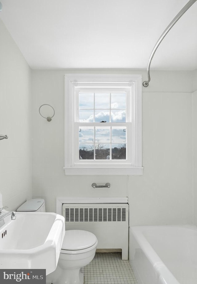 bathroom featuring tile patterned flooring, sink, radiator, a tub, and toilet