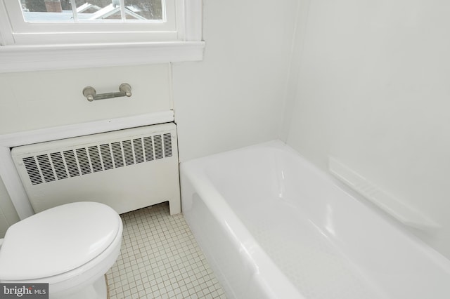 bathroom featuring toilet, radiator, a washtub, and tile patterned flooring