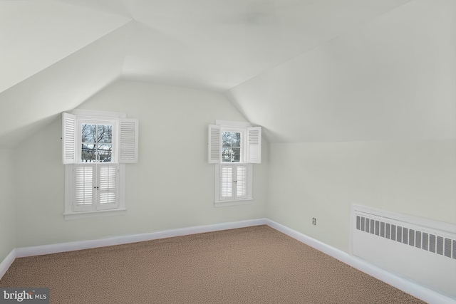 bonus room with carpet, radiator heating unit, and vaulted ceiling