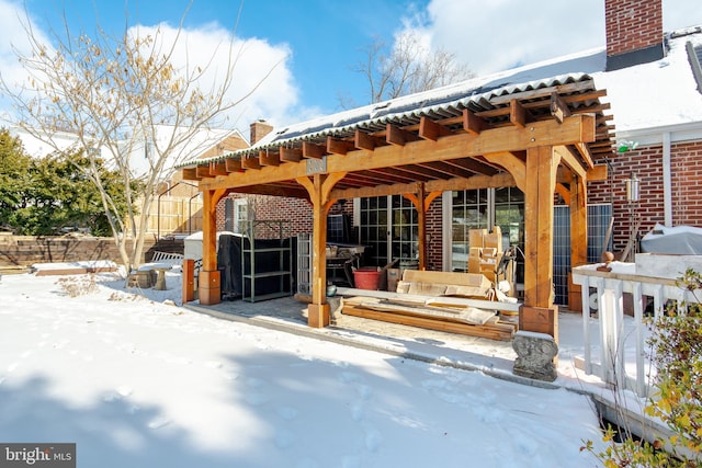 snow covered patio featuring a pergola