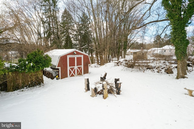 yard covered in snow featuring a storage shed