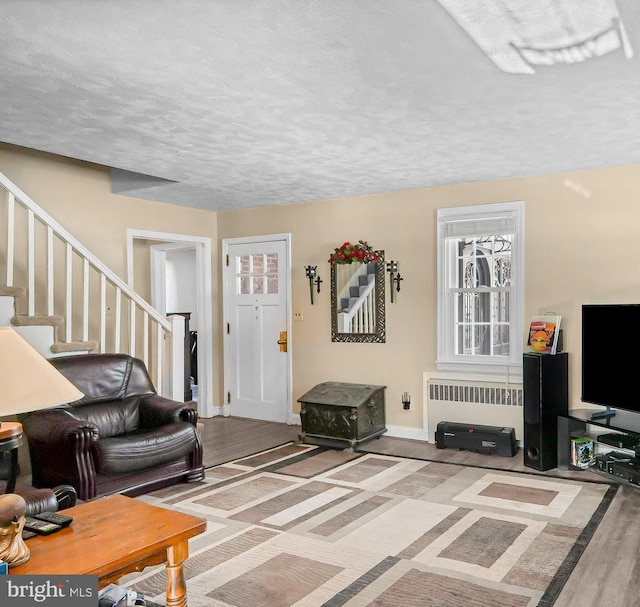 living room featuring hardwood / wood-style flooring, a textured ceiling, and radiator