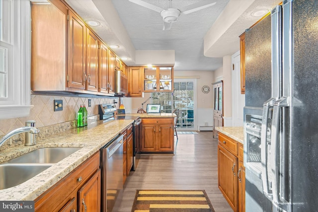 kitchen featuring tasteful backsplash, sink, black fridge, stainless steel dishwasher, and stove