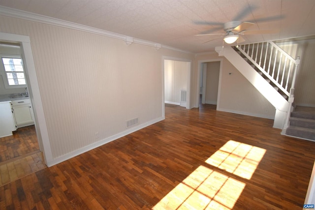 unfurnished living room with ceiling fan, crown molding, and dark wood-type flooring