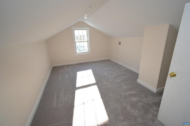 additional living space featuring vaulted ceiling and dark carpet