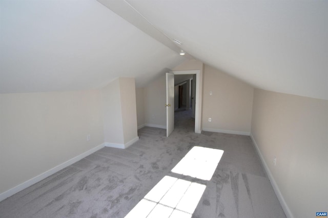 additional living space with light colored carpet and lofted ceiling