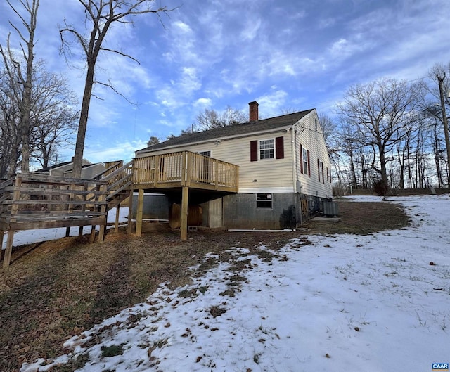 snow covered property featuring cooling unit and a deck