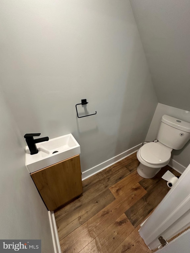 bathroom with vanity, toilet, and hardwood / wood-style flooring