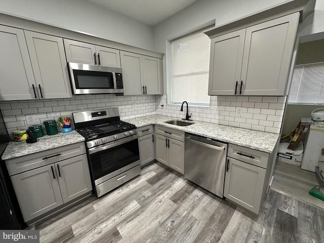 kitchen featuring decorative backsplash, sink, gray cabinets, and stainless steel appliances