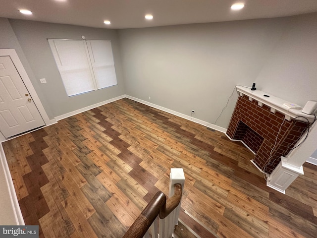 unfurnished living room featuring a fireplace and dark hardwood / wood-style flooring