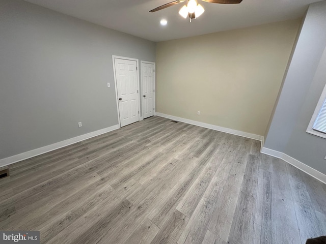 spare room with light wood-type flooring and ceiling fan