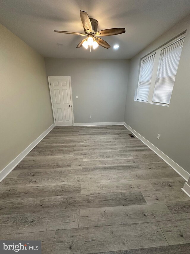 empty room with ceiling fan and light wood-type flooring