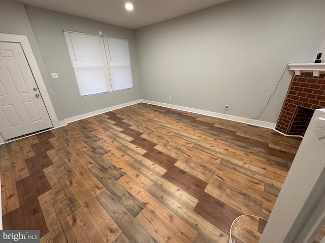 interior space featuring hardwood / wood-style floors and a brick fireplace