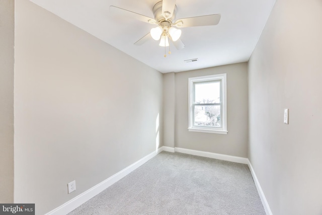 carpeted spare room featuring ceiling fan