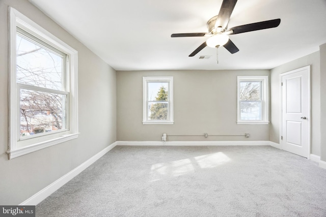 carpeted spare room with ceiling fan and a healthy amount of sunlight