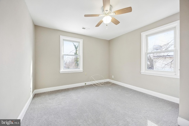 spare room with ceiling fan and carpet