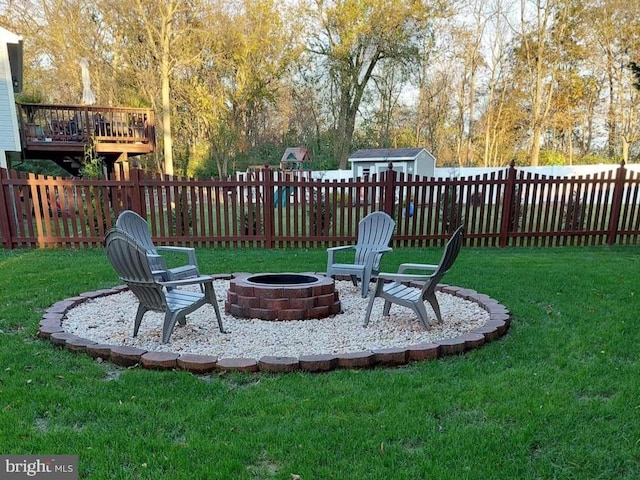 view of yard with a storage shed and an outdoor fire pit