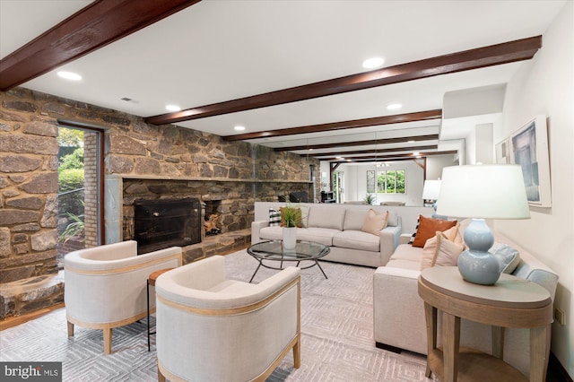 living room featuring beamed ceiling and a fireplace