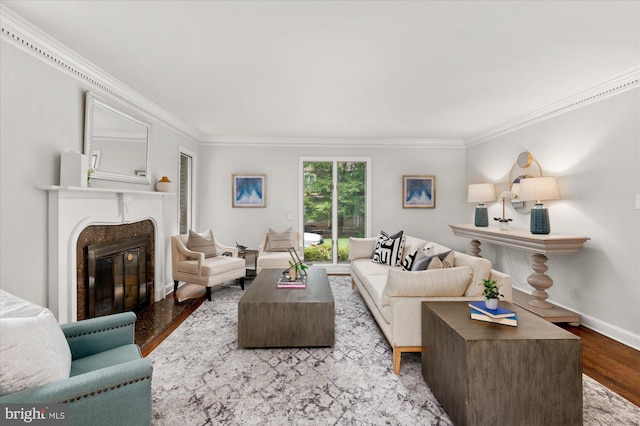 living room featuring light hardwood / wood-style floors, ornamental molding, and a fireplace