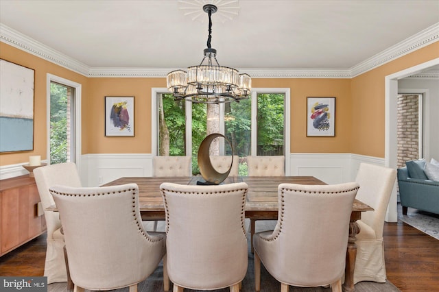 dining space featuring dark hardwood / wood-style floors, a notable chandelier, and ornamental molding