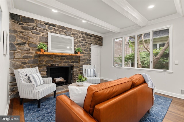 living room featuring a fireplace, hardwood / wood-style floors, beamed ceiling, and ornamental molding