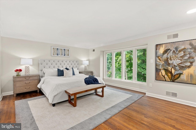 bedroom with crown molding and dark hardwood / wood-style flooring