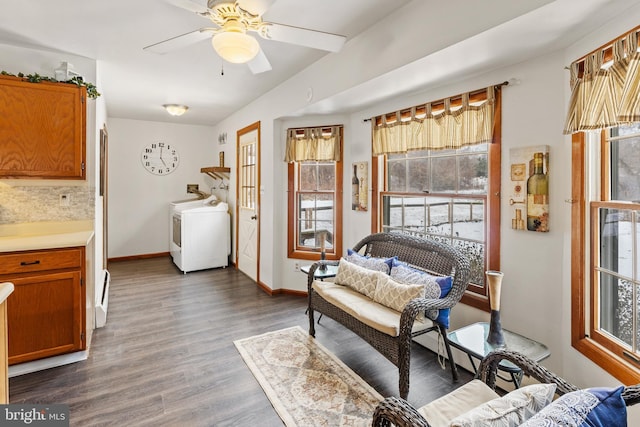 sitting room with dark hardwood / wood-style flooring, washer / clothes dryer, and ceiling fan