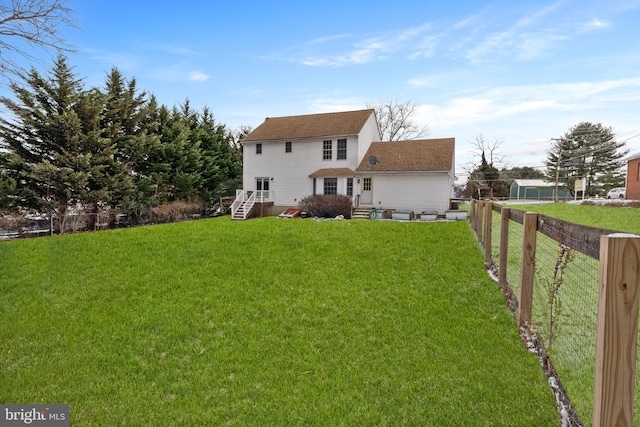 rear view of house featuring a yard