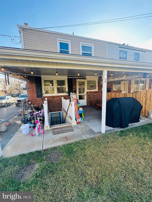 back of property with a yard and a patio