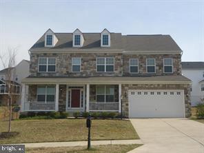 view of front of home featuring a porch, a garage, and a front yard