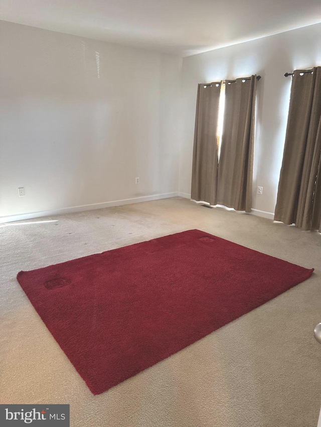 empty room featuring baseboards and carpet floors