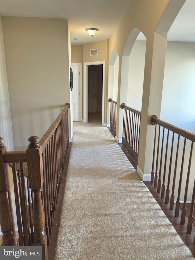 hall featuring visible vents and baseboards