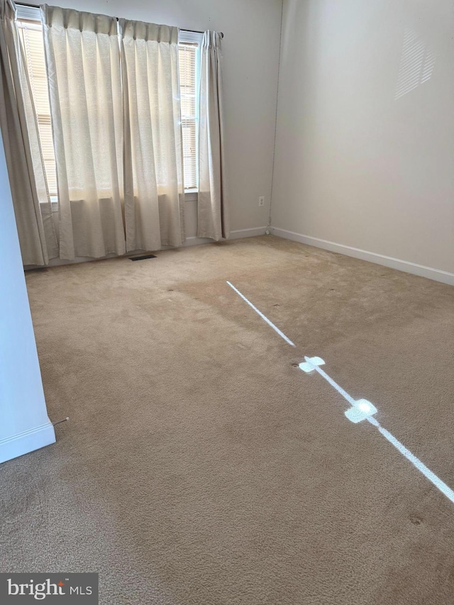 carpeted empty room with baseboards