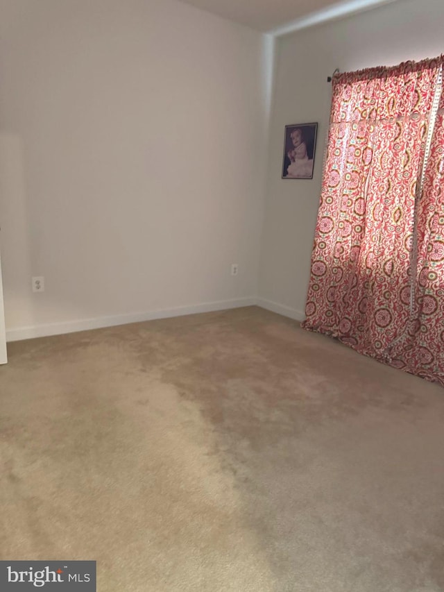 carpeted spare room with baseboards