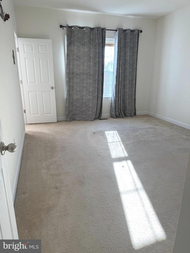 spare room with carpet flooring and baseboards