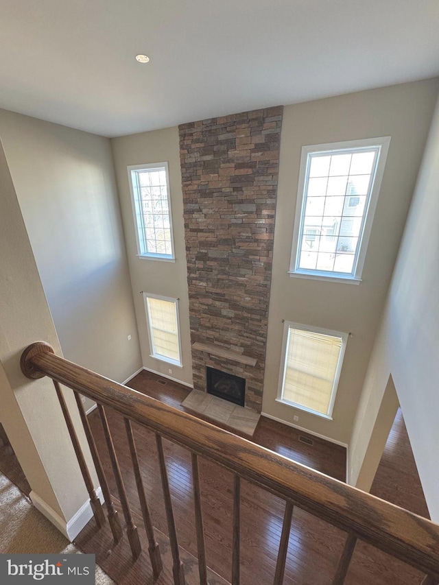 staircase featuring a fireplace and baseboards