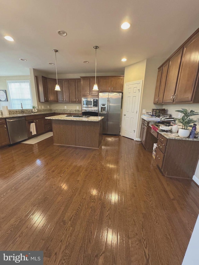 kitchen featuring a center island, recessed lighting, stainless steel appliances, light stone countertops, and dark wood-style flooring