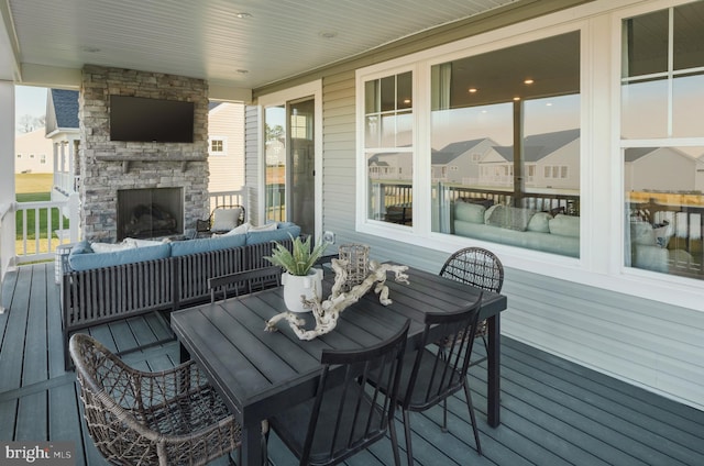 deck with an outdoor living space with a fireplace