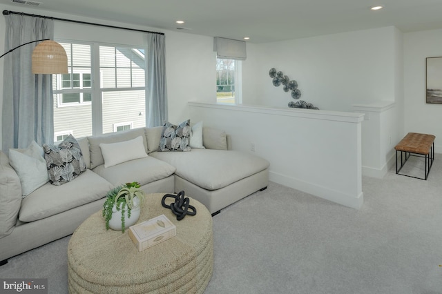 living room featuring light colored carpet and a healthy amount of sunlight