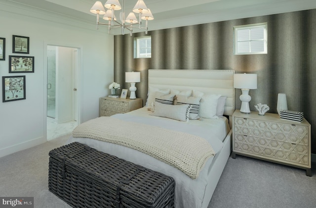 carpeted bedroom featuring crown molding, ensuite bath, and a chandelier