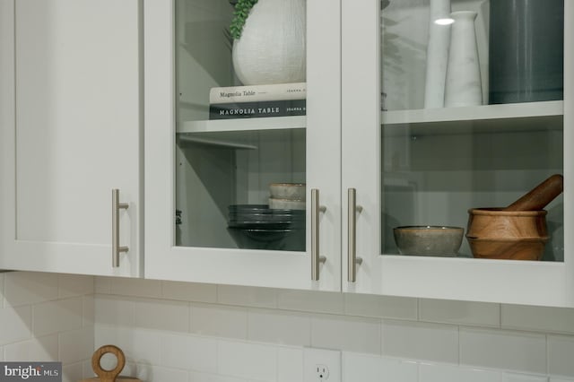 room details featuring decorative backsplash and white cabinets